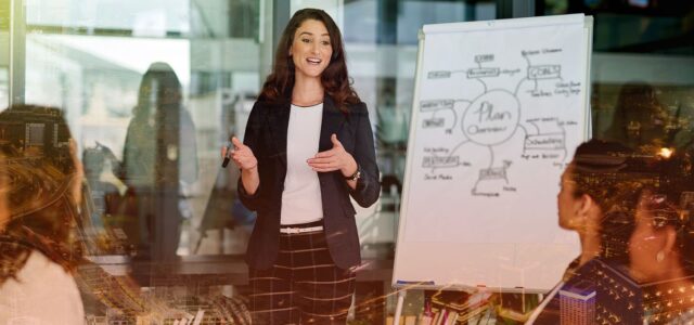 confident woman talking charts with team