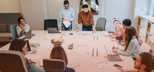 large office table with staff huddled