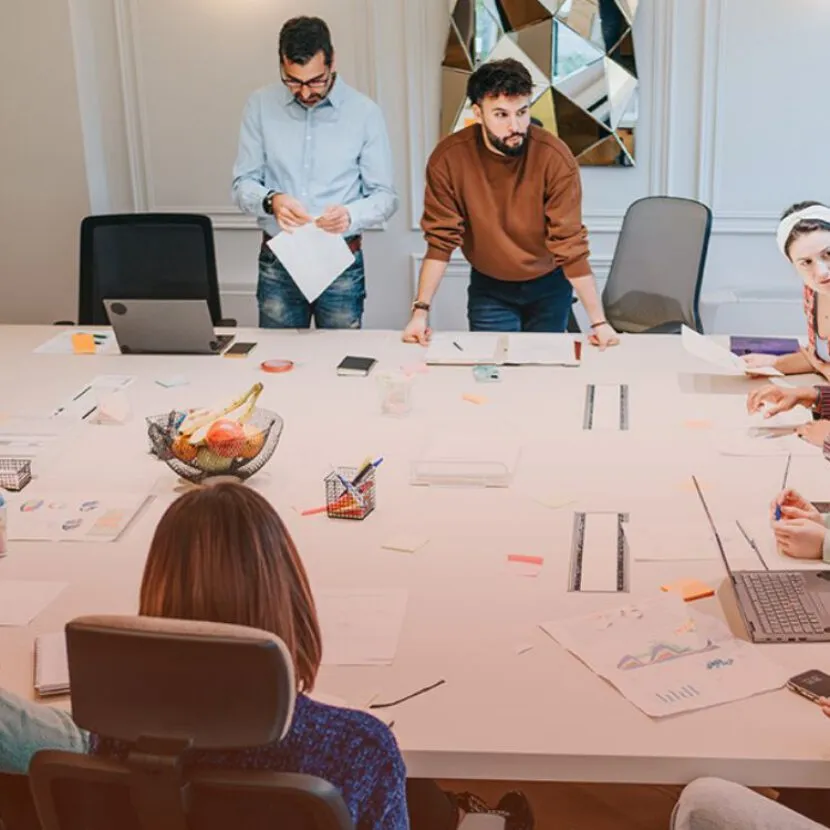 large office table with staff huddled