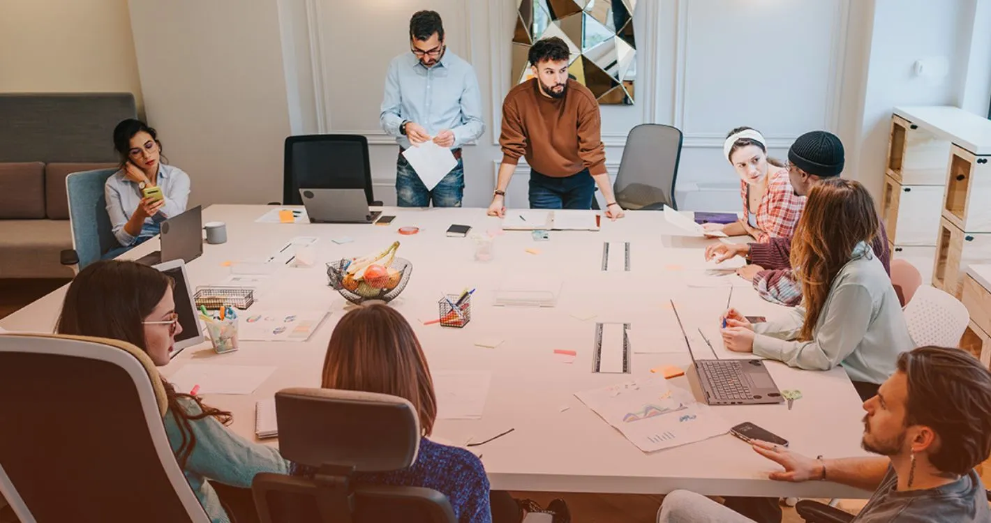 large office table with staff huddled