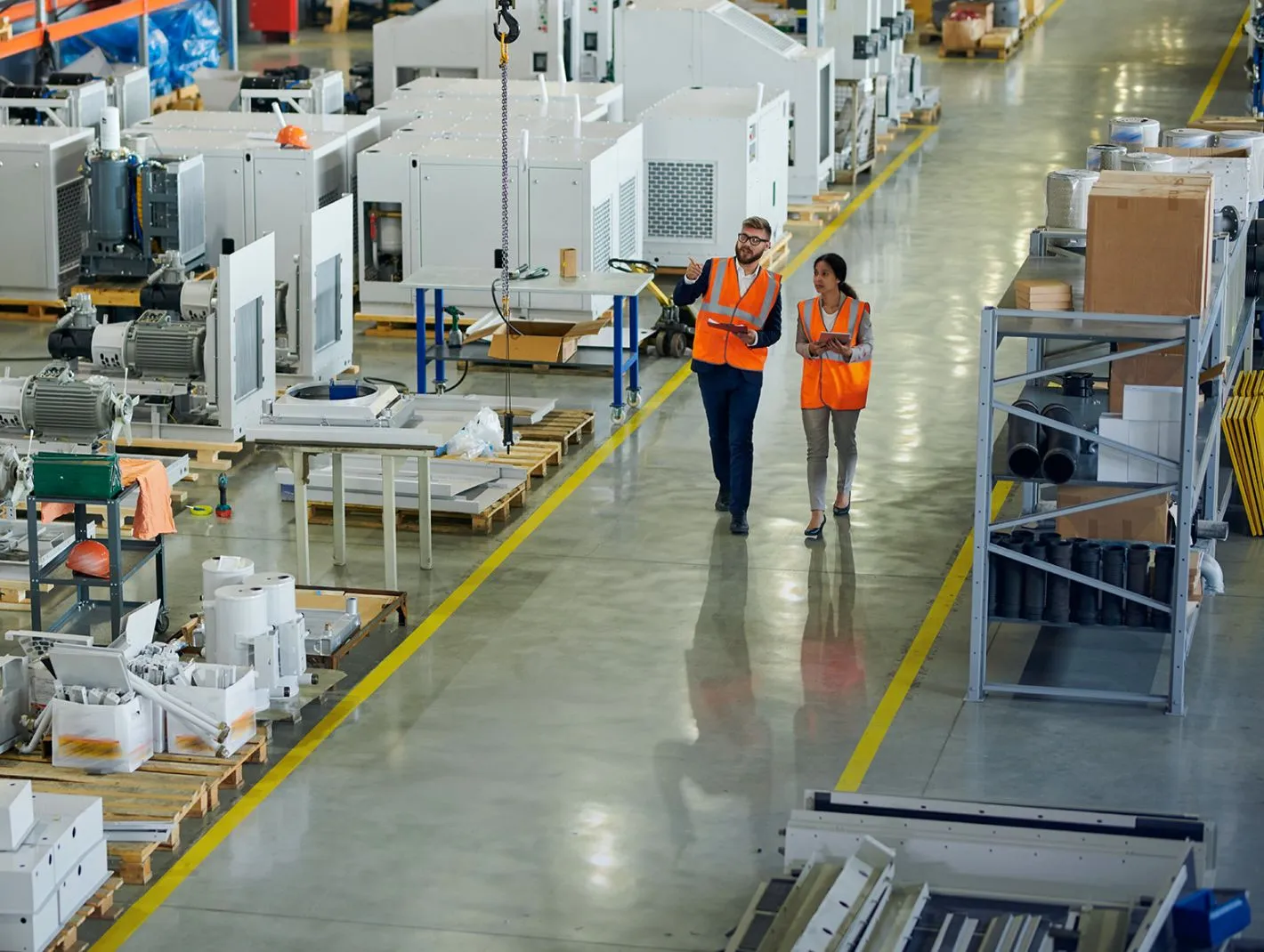 two staff in manufacturing walking the aisles of production floor