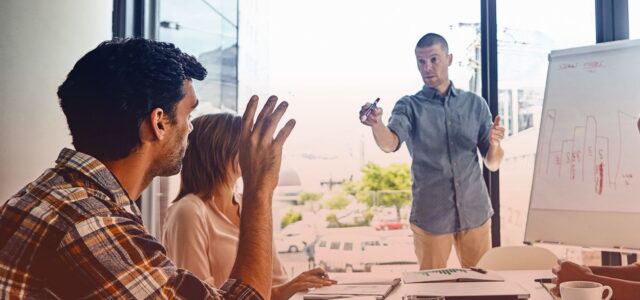 raised hand of man in office asking question