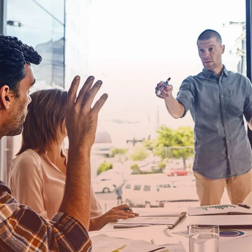 raised hand of man in office asking question