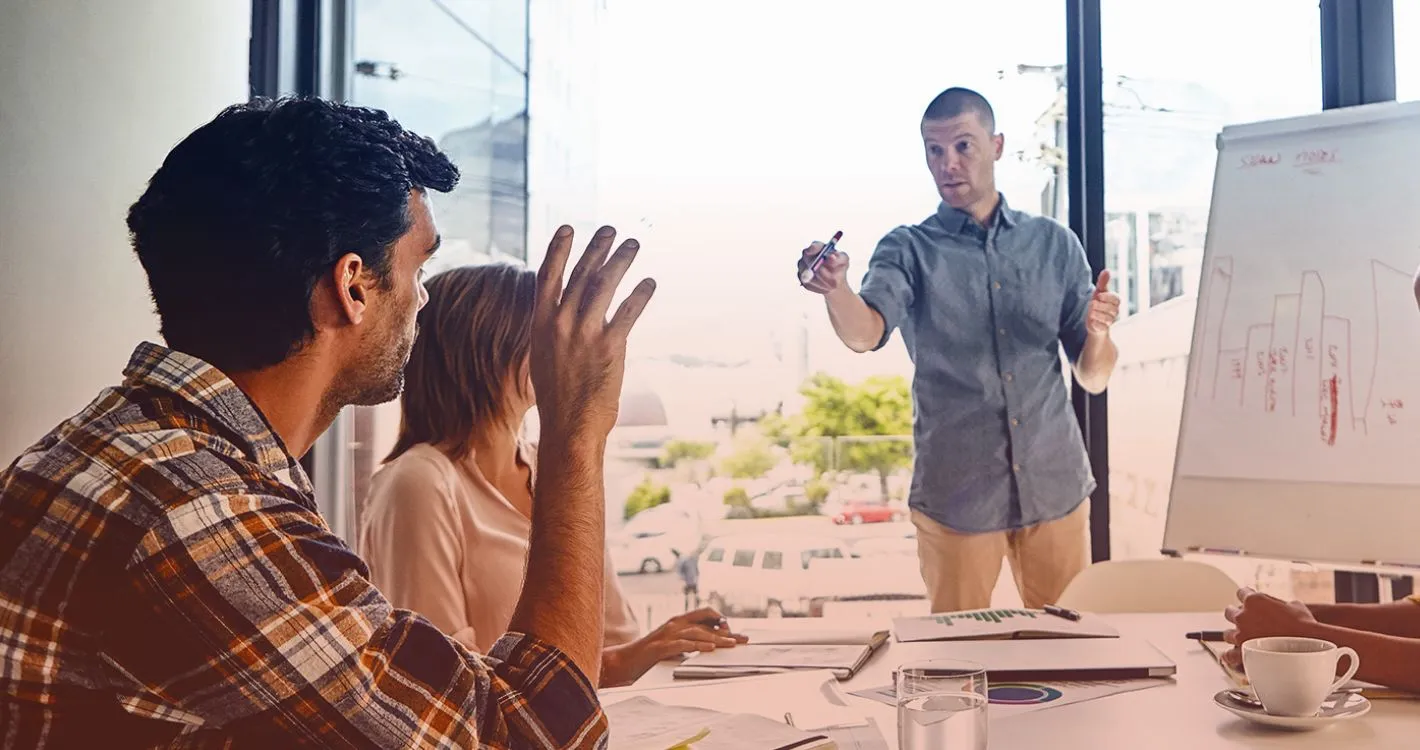 raised hand of man in office asking question