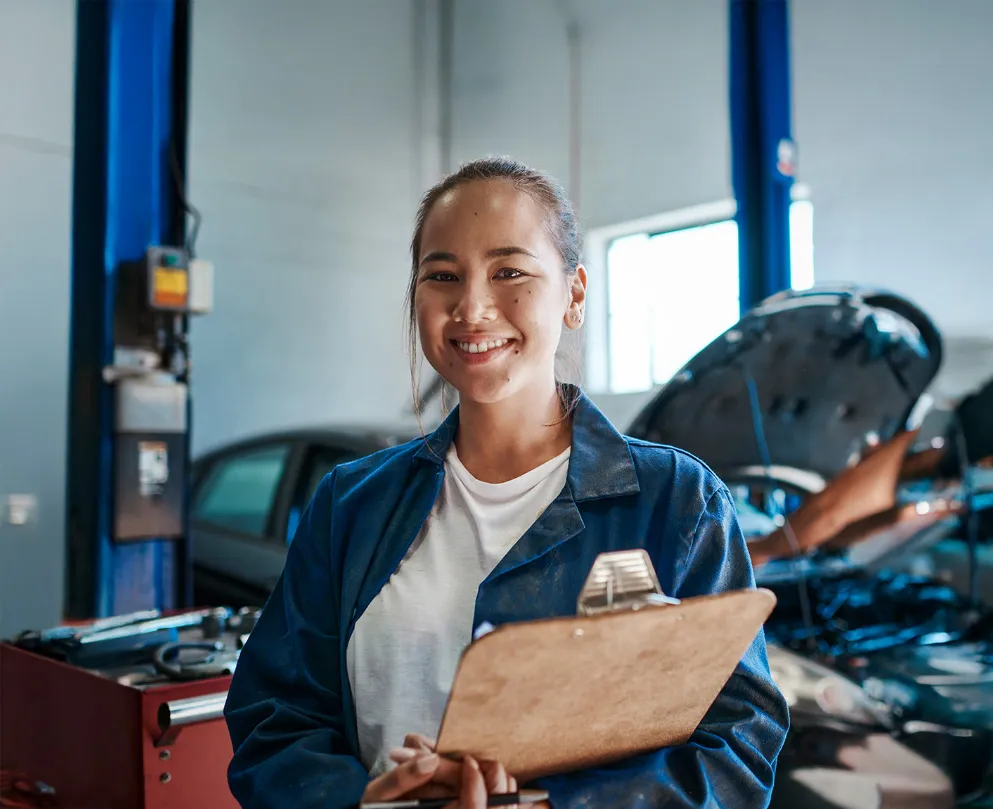 smiling woman in overalls with clipboard